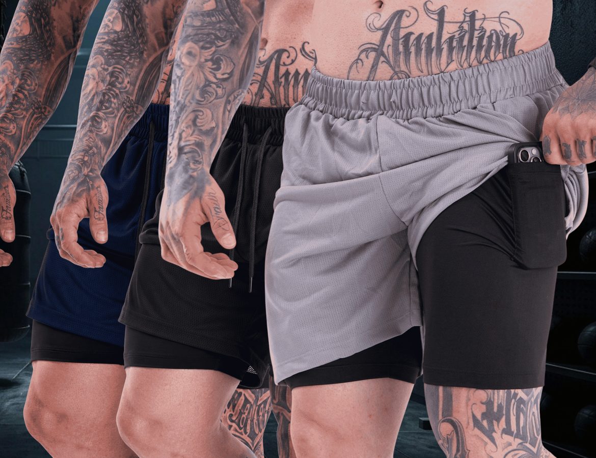 Tres Shorts 2 em 1 Vankoff, nas cores preta, marinho e cinza, vestidos por modelos numa academia de fundo escuro.